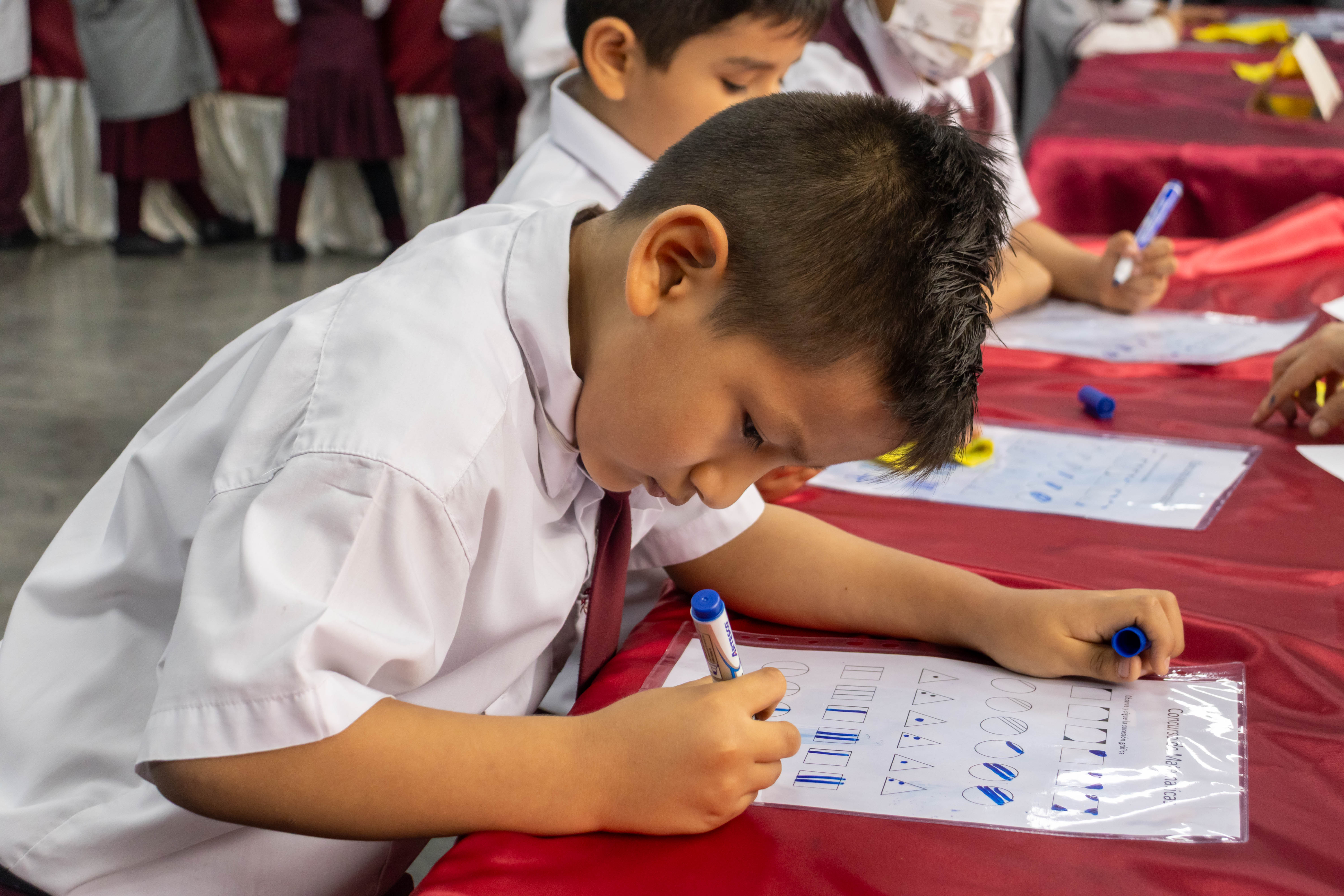 Estudiante de primaria escribiendo en clase
